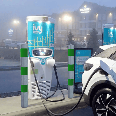 Verzinkt-groene aanrijdbeveiliging palen (Ø76-102 mm) beschermen een laadpaal en elektrische auto.