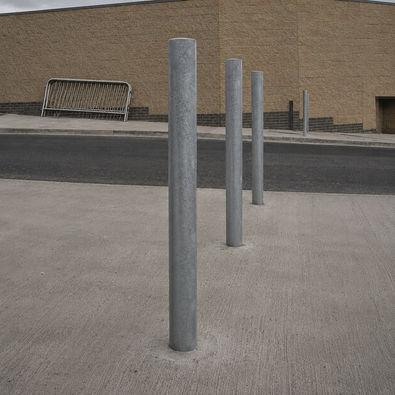 Verzinkt stalen afzetpaal Ø76 mm, grijs, staand op een betonnen ondergrond bij een parkeergarage