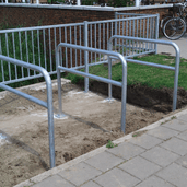 Zilverkleurige stalen beschermbeugels Ø60 mm met tussenbuis, op voetplaat, in een onafgewerkte omgeving.