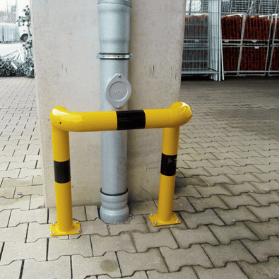 Gele en zwarte stalen kolombeschermer Ø76 mm met 2x 90° hoeken, verankerd in beton.
