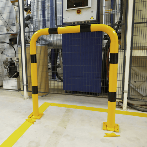 Gele en zwart gestreepte beschermbeugel Ø76 mm op verwijderbare voetplaten in een industriële omgeving.