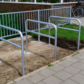 Verzinkt stalen beschermbeugel Ø48 mm met tussenbuis, op voetplaat, in een onafgewerkte buitenomgeving.
