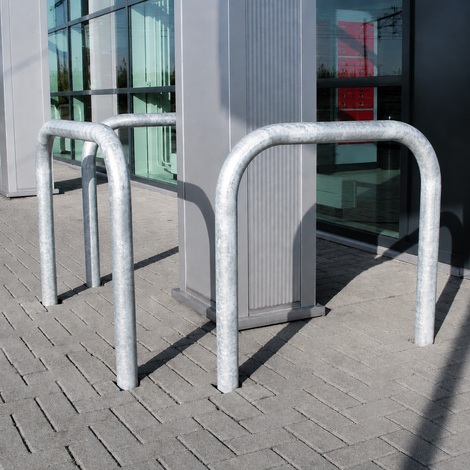 Verzinkt stalen beschermbeugel Ø60 mm, U-vormig, verankerd in betonnen bestrating.