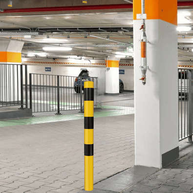 Gele en zwarte beschermpaal Ø102 mm in parkeergarage, voor betonverankering of op voetplaat.