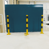Drie gele en zwarte verwijderbare beschermpalen op voetplaten, voor industriële veiligheid.
