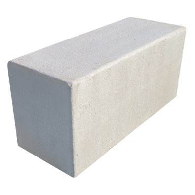 Grijze betonnen poef, rechthoekig, met een gladde, matte afwerking.