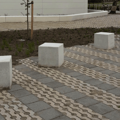 Drie grijze betonnen poefs van 500x500x500 mm op een bestrate buitenruimte.