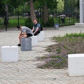 Grijze betonnen poef van 500x500x500 mm, strak en modern design, ideaal voor openbare ruimtes.