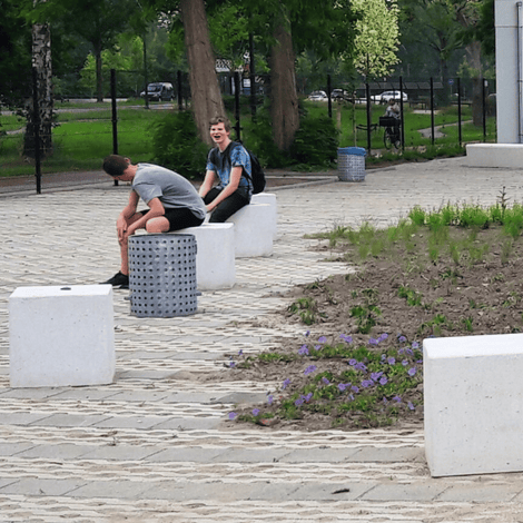Grijze betonnen poef van 500x500x500 mm, strak en modern design, ideaal voor openbare ruimtes.