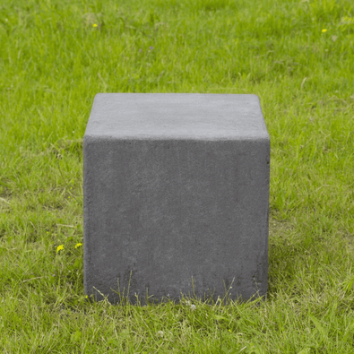Antraciet betonnen poef, kubusvormig, 600x600x600 mm, staand op groen gras.