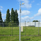 Zilveren cameramast, 4-8 meter, met witte bewakingscamera en beige behuizing, voor grond- of vloermontage.