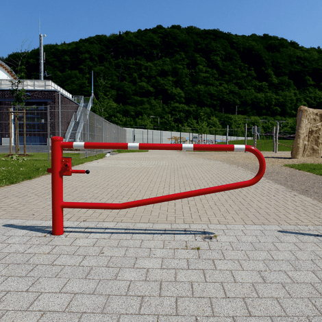 Rood-witte draaiboom op voetplaat, 150-350 cm, met handmatige bediening op een bestraat terrein.