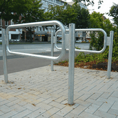 Verzinkt stalen fietsbeugel design met buis Ø60/48 mm, gemonteerd op een trottoir.