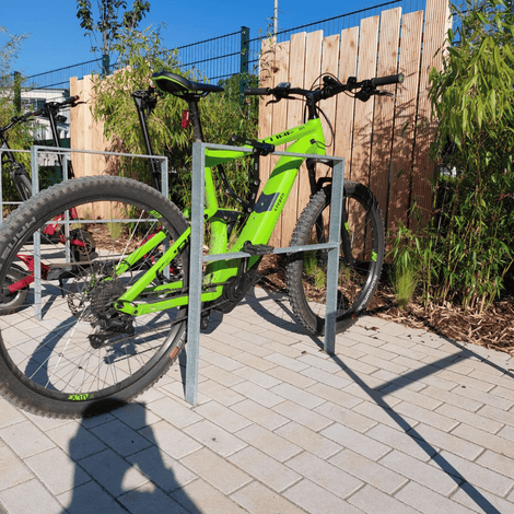 Verzinkte fietsbeugel van plat staal 50x12 mm met een felgroene e-bike.