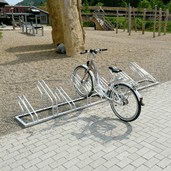 Enkelzijdig fietsenrek van verzinkt staal met een witte fiets, geschikt voor meerdere fietsen.