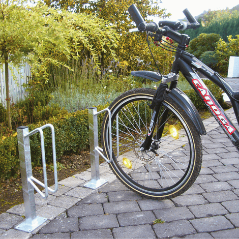Verzinkt stalen individueel fietsenrek voor muurbevestiging, met een zwarte fiets geparkeerd.