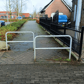 Verzinkt stalen fietssluis hek (Ø48 mm) voor in beton verankering, op een bestraat pad.