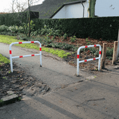 Wit-rood Ø48 mm fietssluis hek, in beton verankerd, op een fietspad.