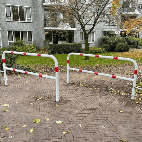 Wit-rood Ø60 mm uitneembaar fietssluis hek met slot, geplaatst op een klinkerpad.