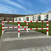 Wit-rood fietssluis hek met uitneembaar slot, 70x70 mm, op een fietspad.