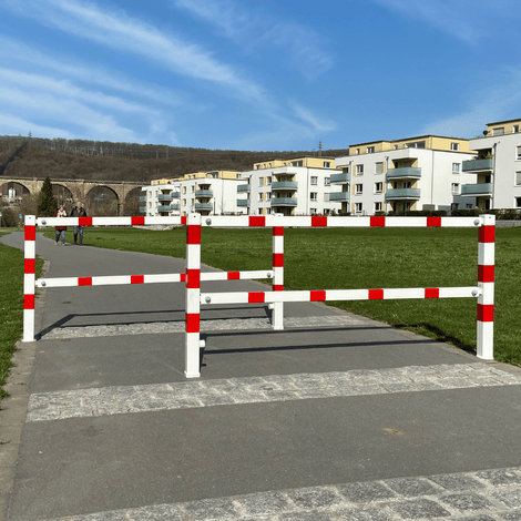 Wit-rood fietssluis hek met uitneembaar slot, 70x70 mm, op een fietspad.