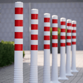 Rood-witte flexibele paaltjes in verschillende hoogtes, met reflecterende strepen en een stevige basis.