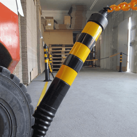 Zwart-gele flexibele paaltjes met oranje ketting, 450-1000 mm hoog, voor industriële afbakening.