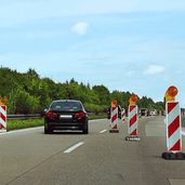 Geleidebaken klasse 2 folie, rood-wit gestreept, met oranje knipperlichten langs een snelweg.