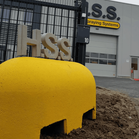 Gele Jumboblok van Oud Hollands stampbeton met lepelgaten, voorzien van HSS-logo.