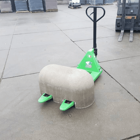 Grijze Jumboblok van Oud Hollands stampbeton met lepelgaten, op een groene pompwagen.