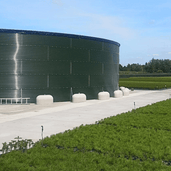 Wit Jumboblok van Oud Hollands stampbeton met hijsoog, 330 kg, ondersteunt een grote groene watertank.