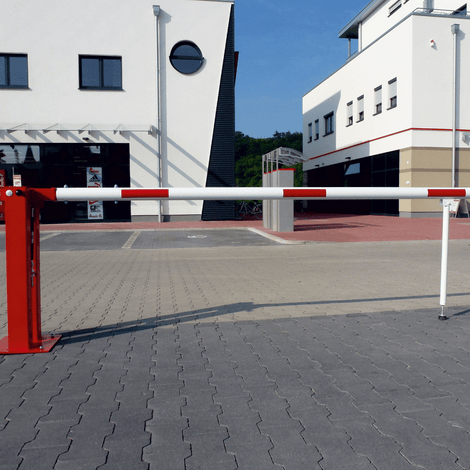 Rood-witte mobiele slagboom met gasveer en pendelsteun, 300-700 cm, op parkeerterrein.