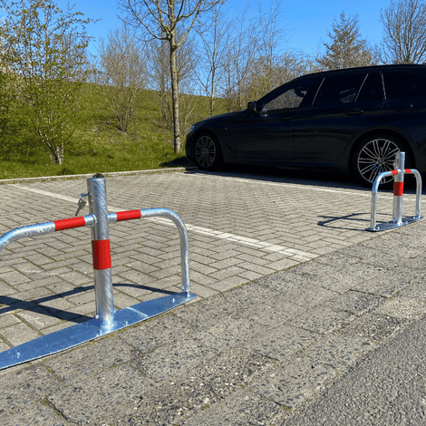 Verzinkt stalen parkeerbeugel met cilinderslot en rode reflecterende strepen op volledige voetplaat.