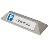 Grijze betonnen stootband met blauw "P" en "Bezoekers" bord voor parkeerplaatsen.