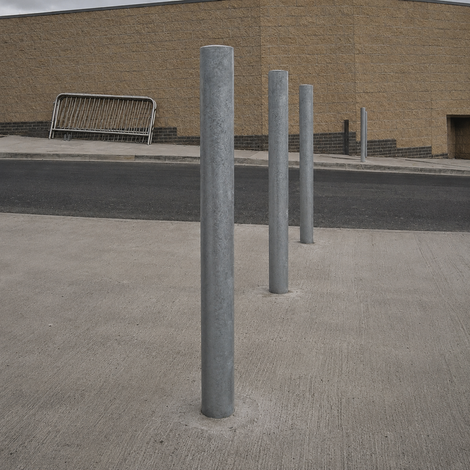 Verzinkt stalen parkeerpaal Ø76 mm, grijs, staand op een betonnen ondergrond bij een parkeergarage
