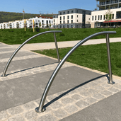 RVS fietsbeugel Ø48 mm, gebogen design, voor verankering in beton of op voetplaat, in stedelijke omgeving.