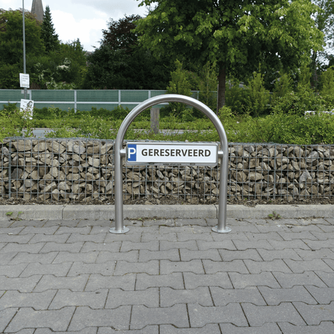 RVS houder met gebogen design voor parkeerbord "P GERESERVEERD", staand op een parkeerplaats.