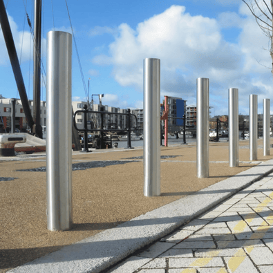 RVS parkeerpalen Ø102 mm, glanzend zilver, op een rij langs een kade.