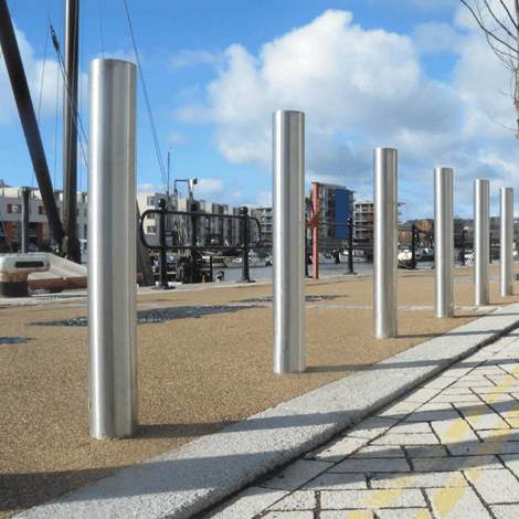 RVS parkeerpalen Ø102 mm, glanzend zilver, op een rij langs een kade.