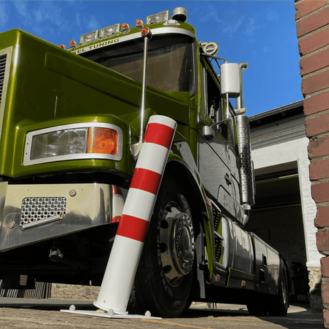 Wit-rode rampaal Ø152 mm op verende voetplaat, staand voor een groene vrachtwagen.