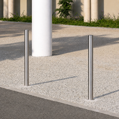 Twee RVS afzetpalen Ø60 mm, zilverkleurig en strak, verankerd in een moderne buitenomgeving.