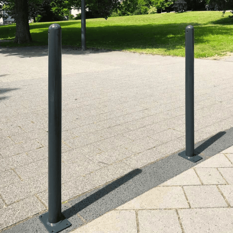 Trottoirpaal Ø76 mm met puntkop, antracietgrijs, staal, op een bestrate ondergrond.