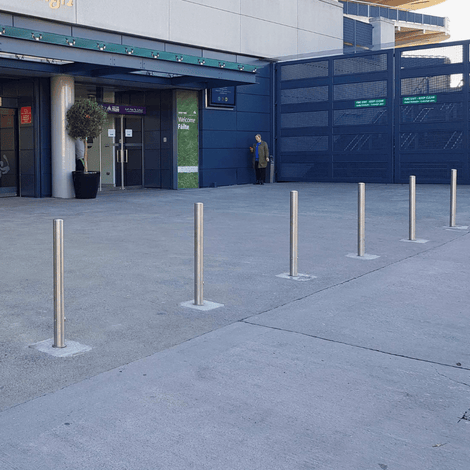 RVS uitneembare afzetpalen (Ø76 x 900 mm) met slot, op een rij voor een gebouw.