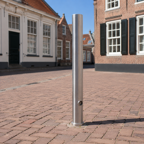 Uitneembare rvs parkeerpaal 89 mm met driekantslot en betonvoet in een klassiek dorp straatje