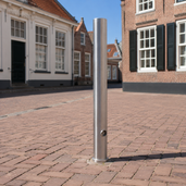 Uitneembare rvs parkeerpaal 89 mm met driekantslot en betonvoet in een klassiek dorp straatje