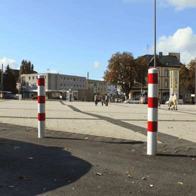 Twee wit-rode uitneembare afzetpalen Ø102 mm met betonvoet op een plein.