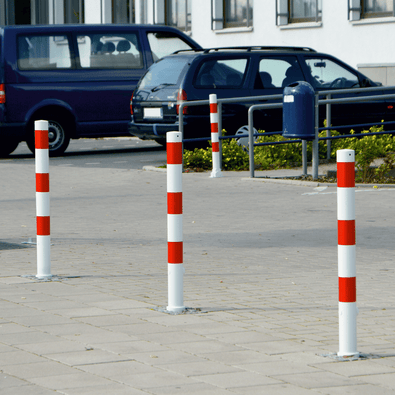 Witte en rood gestreepte uitneembare parkeerpalen Ø76 mm op een parkeerplaats.