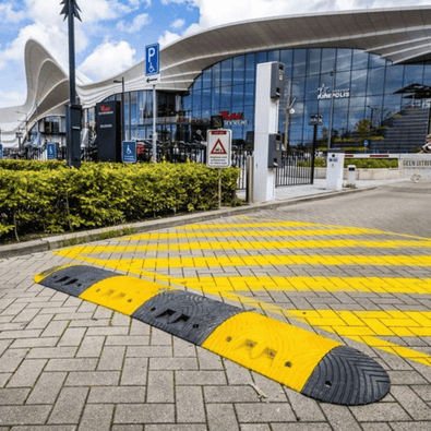 Zwarte en gele rubberen verkeersdrempel van 7 cm hoog op een parkeerplaats.