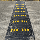 Zwarte verkeersdrempel van 5 cm met gele reflecterende markeringen, geschikt voor vrachtwagens.