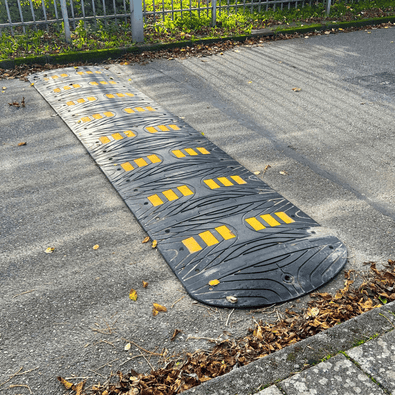 Zwarte verkeersdrempel van 5 cm met gele reflecterende strepen, geschikt voor vrachtwagens.